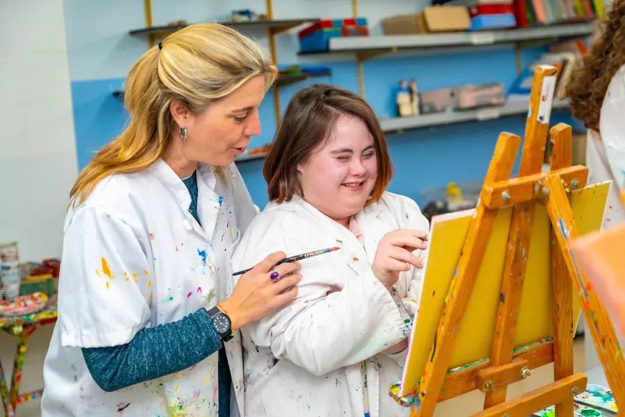 Disabled woman and support worker in art class