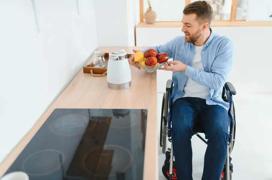Disabled man in wheelchair holding fruit bowl