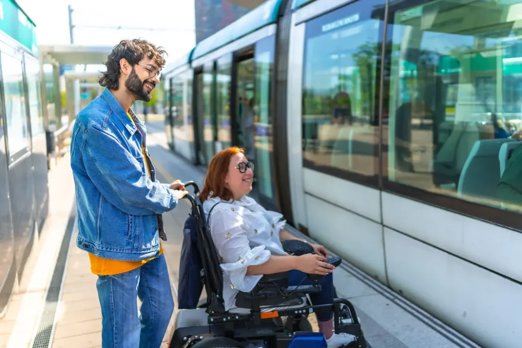Disabled woman getting on train with support worker